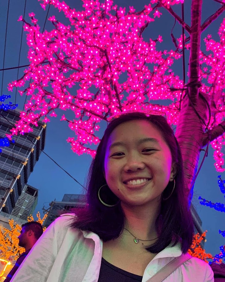 portrait of Linda smiling in front of blue and pink lights